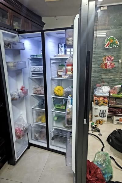 nhân viên kiểm tra tủ lạnh tại nhà