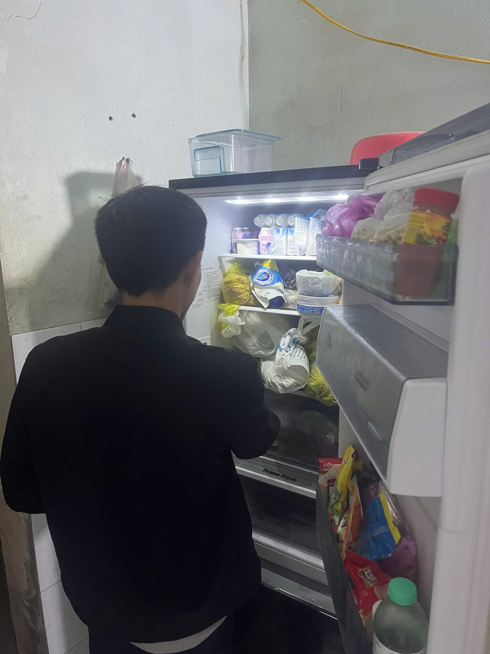 nhân viên kiểm tra tình trạng tủ trước khi sửa